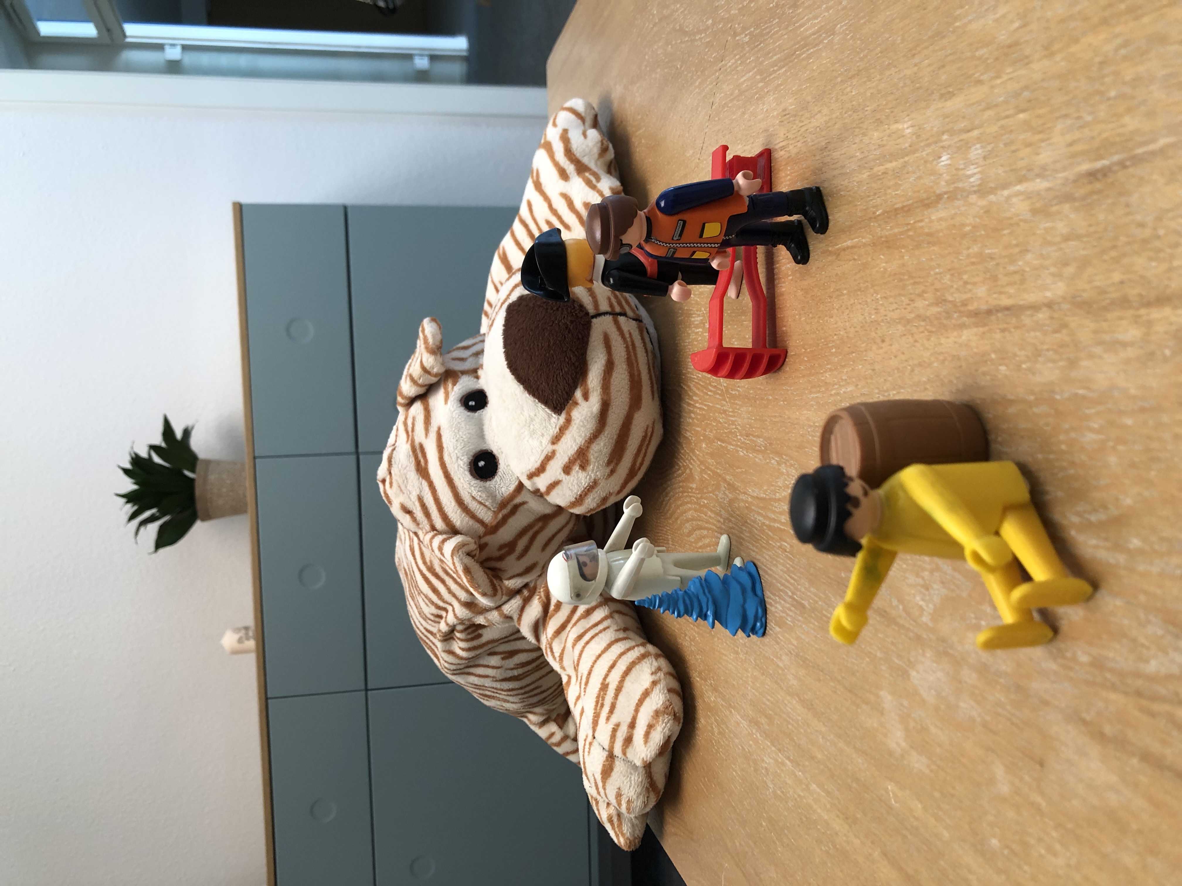 Tiga, die Stofftigerin aus meiner Praxis, mit einer kleinen Playmobil-Szene auf dem Tisch.